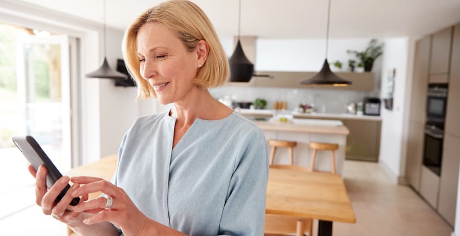 Woman with smartphone in a room filled with sunlight